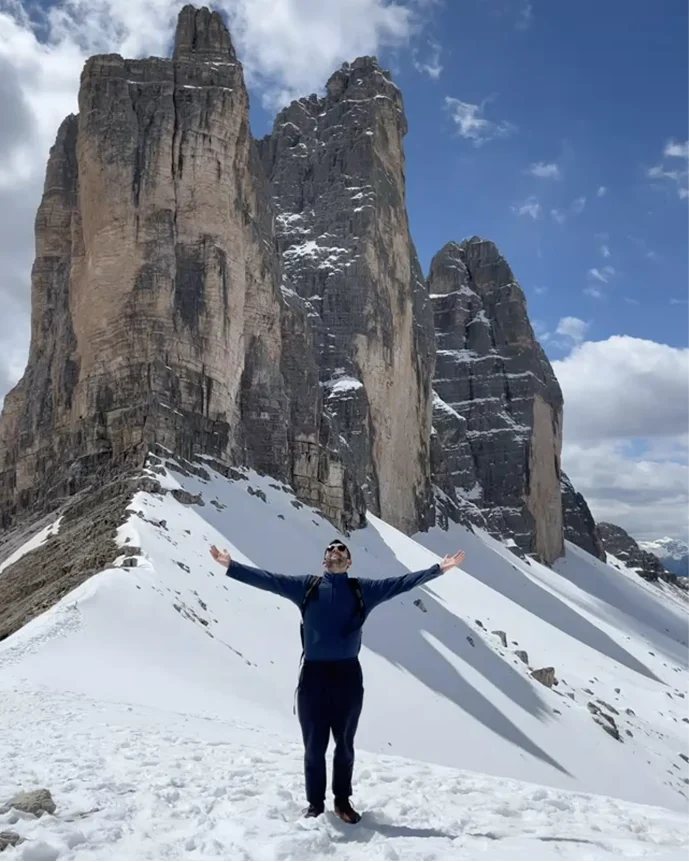 Matteo Capalbo in montagna sulle Tre Cime di Lavaredo, braccia aperte sulla neve