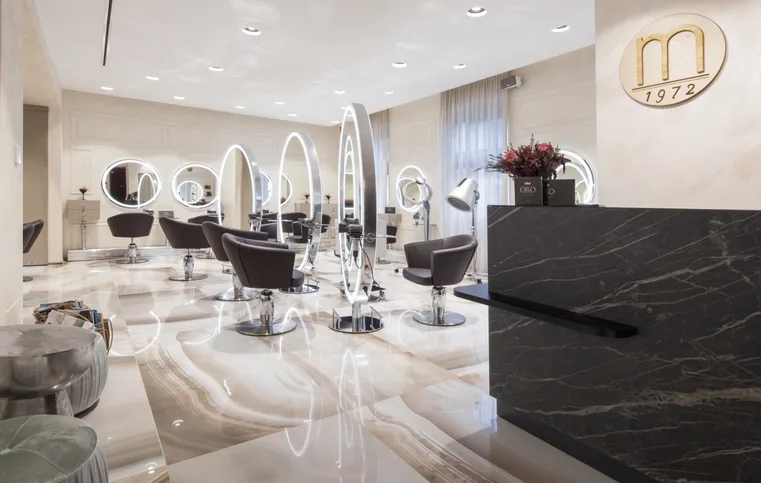 Interno di un salone di bellezza con postazioni e specchi
